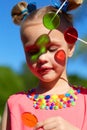 Girl smiles and looks at transparent multi-colored lollipops Royalty Free Stock Photo