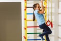 The girl smiles, plays and goes in for sports on the stairs and the Swedish wall in the children& x27;s center in special Royalty Free Stock Photo