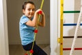 The girl smiles, plays and goes in for sports on the stairs and the Swedish wall in the children's center in special Royalty Free Stock Photo