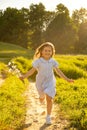 The girl smiles and runs with a bouquet of daisies. Royalty Free Stock Photo