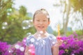 Girl smiling while blowing bubles in park Royalty Free Stock Photo