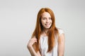 Girl smiling with closed eyes touching her red hair over white background Royalty Free Stock Photo