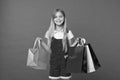 Girl on smiling face carries bunches of shopping bags, isolated on white background. Girl likes to buy fashionable Royalty Free Stock Photo