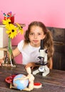 Girl with smiling face near globe and microscope