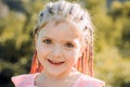 Girl smiling with hairstyle dreadlocks. Kid with fashionable hair outdoor. Happy child outside. Royalty Free Stock Photo