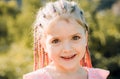 Girl smiling with hairstyle dreadlocks. Kid with fashionable hair outdoor. Happy child outside. Royalty Free Stock Photo