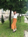 Girl smiling near a flowering tree. Outdoor portrait of a young beautiful fashion lady posing near a blossoming tree. Women`s Royalty Free Stock Photo