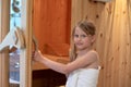 A girl is smiling and opens the door of the Finnish sauna Royalty Free Stock Photo