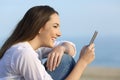 Girl smiling reading on line content in a smart phone