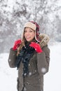 Girl smiling in the snow wearing a lumberjack hat