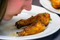 Girl sniffs fried chicken legs on plate