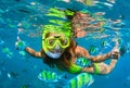 Girl in snorkeling mask dive underwater with coral reef fishes