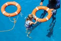 A girl in a mask with an instructor holds on to a lifebuoy