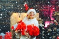 Girl in snow. Young woman with christmas present boxes in front of christmas tree. Cheerful young woman wearing Royalty Free Stock Photo