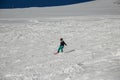 a girl on a snowboard rides down the side of the mountain