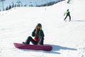 Girl with a snowboard sitting on a snowy slope. Sport. Royalty Free Stock Photo