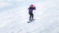 Girl snowboarder descends from the mountains in the snow on a snowboard Royalty Free Stock Photo