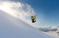 Girl snowboarder jumping front flip leaving a wave of snow