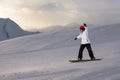 Girl snowboarder rides down slope