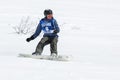 Girl snowboarder rides steep mountains. Russia, Far East, Kamchatka Peninsula