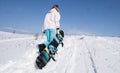 Girl snowboarder with a snowboard on a white snow.