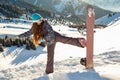 Girl snowboarder stands mountain top with snowboard in hands.