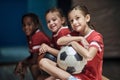 Girl with soccer ball in good mood before training in changing room