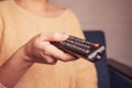 a girl holding in her hands a remote control from the TV Royalty Free Stock Photo