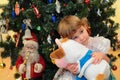 Girl with soft toy under New Year`s tree Royalty Free Stock Photo