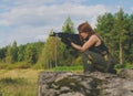 Girl soldiers take aim from the gun being on a hill