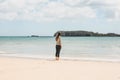 A girl in solitude on the beach looks into the distance