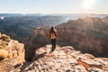 Girl solo hiker traveler on the edge of a cliff watching a beautiful view of Grand Canyon West Rim