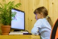 A girl solves a problem on a computer during distance learning