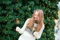 Girl with a sparkler near brightly Christmas tree