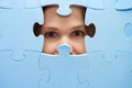 The girl spies through a blue puzzle