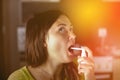 The girl splashes in her mouth with a spray from the pain in her throat. Treatment of colds, flu.