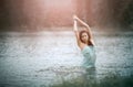 Girl splashing water in lake by her hands. Motion Royalty Free Stock Photo