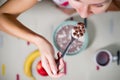 Girl, spoon with chocolate cereals and milk