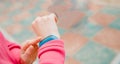 Girl sport uses finger touches fitness bracelet to measure heart rate and number steps, useful technology Royalty Free Stock Photo