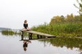 Girl with sports figure on background of calm autumn river. Yoga, Meditation, Relax Royalty Free Stock Photo