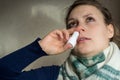 Sick girl sprays the spray from runny nose into the nasal pass Royalty Free Stock Photo