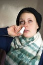 Sick girl sprays the spray from runny nose into the nasal pass Royalty Free Stock Photo