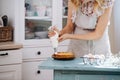 Girl spreads cream cheese on a cake with a pastry bag Royalty Free Stock Photo