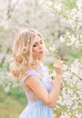 Girl in a spring garden admiring flowers. Portrait in profile. Flowers in your hair