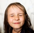 the girl squeezed her eyes shut, the happy child is smiling,the happy preschooler Royalty Free Stock Photo