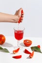 The girl squeezes the juice from the orange hand in a glass. Cut oranges on a light background Royalty Free Stock Photo
