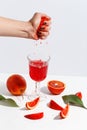 The girl squeezes the juice from the orange hand in a glass. Cut oranges on a light background Royalty Free Stock Photo