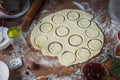 The girl squeezes round shapes out of the dough with a glass