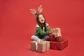 Girl and a stack of Christmas gifts