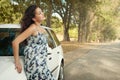 Girl stand on country road near car, big high trees, summer season Royalty Free Stock Photo